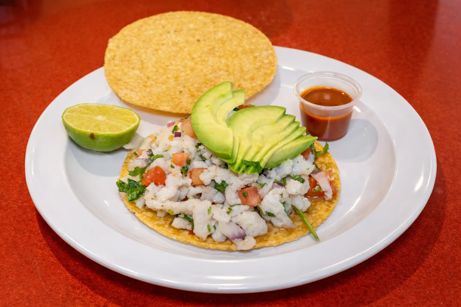Tostada de ceviche con aguacate, limón y salsa