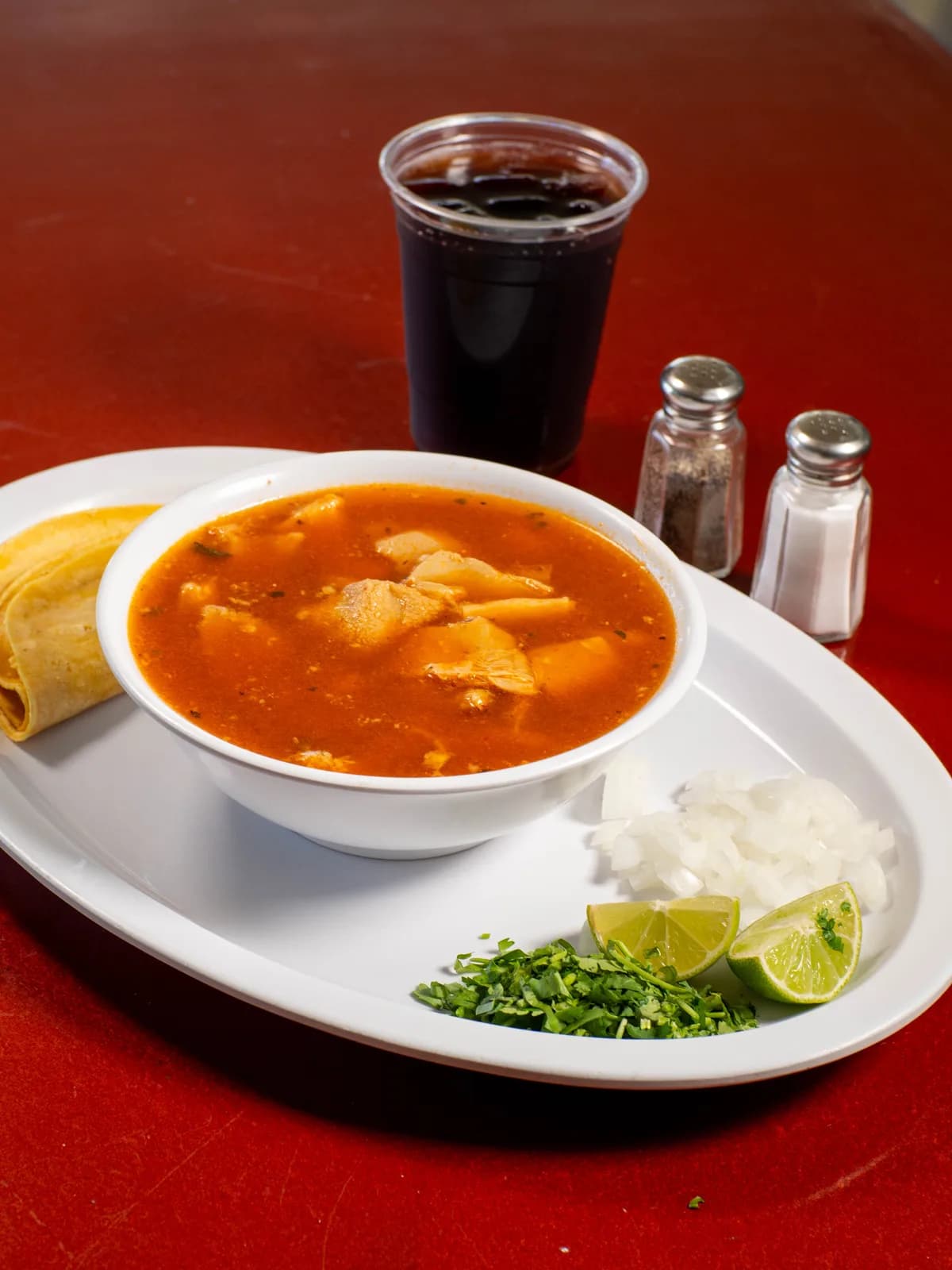 Menudo con limón, cebolla, cilantro y tortillas